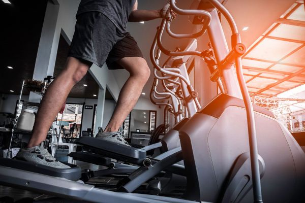 Landmark Tower Person using an elliptical machine in a gym with sunlight streaming through the window.